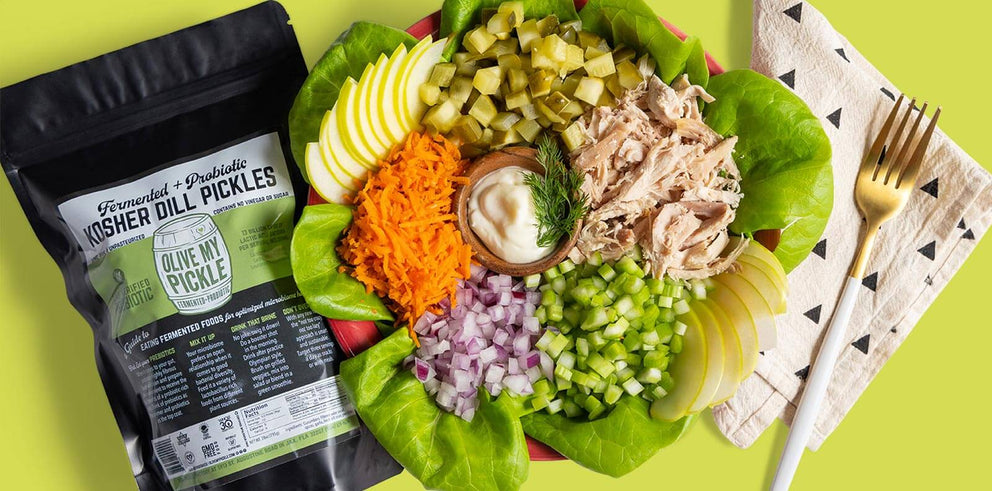Fresh salad next to a package of Olive My Pickle Kosher Dill Pickles