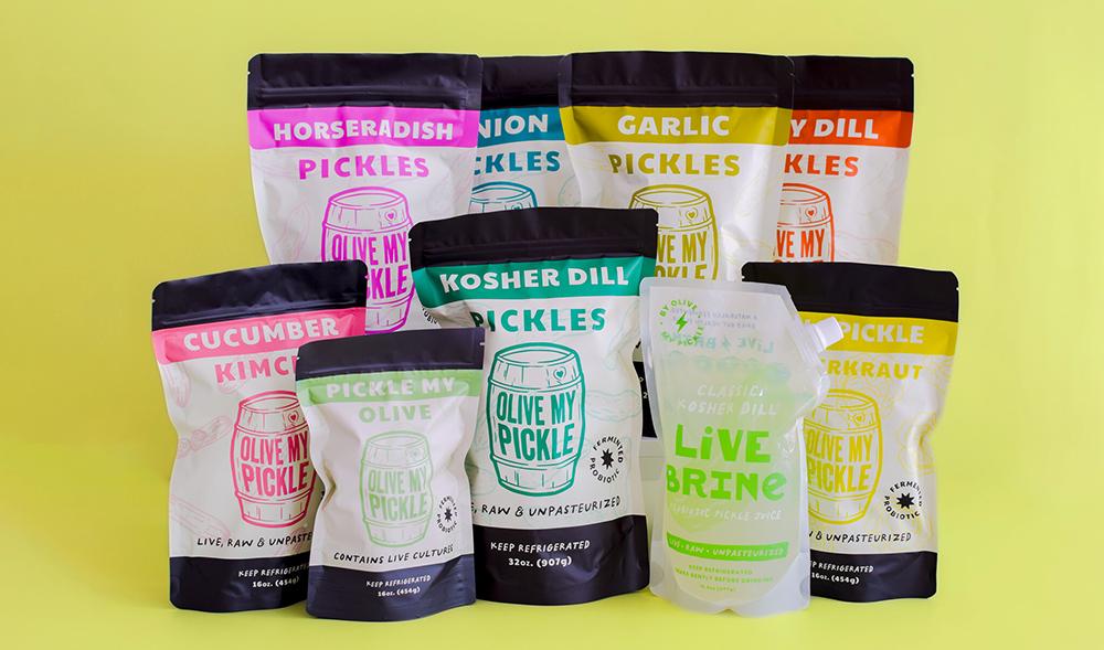 A variety of Olive My Pickle products displayed in bowls with their packages