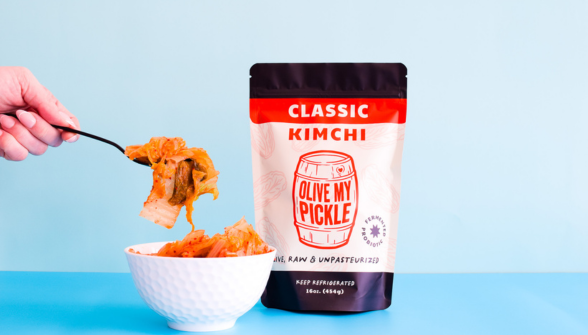 Classic Kimchi, fermented food, bowl of kimchi, hand scooping kimchi, blue background, white bowl