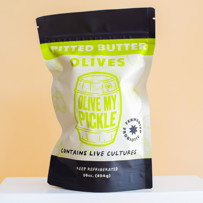 Buttered Olives by package with green and yellow label on beige background