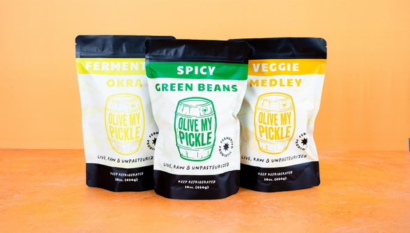 Three pouches of spicy green beans variants displayed side by side on orange background