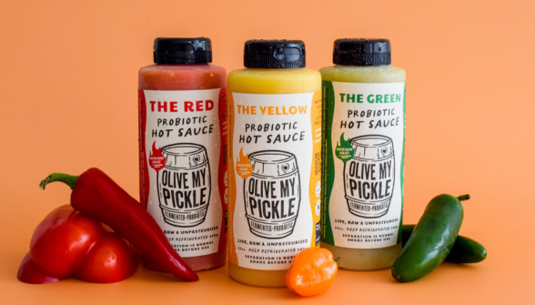 A collection of four jars of pickles, each labeled with different flavors: "The Red Hot, " "The Green, " "The Original, " and "The Pickle