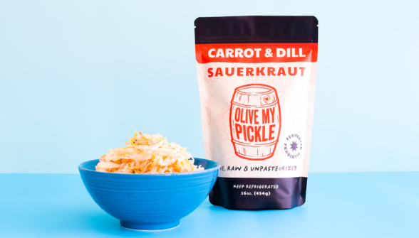 Carrot & Dill Sauerkraut package with shredded carrots in a blue bowl on a light blue background