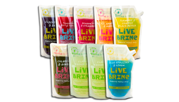 A collection of six bottles of Livebrine fermented drinks, each with a different color label, displayed on a surface.